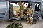 Officer and maintainer from 56th Helicopter Maintenance Unit (HMU) show how the multiple coiled rope is fitted to the extended support in the HH-60G. It can be fitted on both side of the helicopter and it provides the pararescueman a fast rappelling while the HH-60G is hovering
