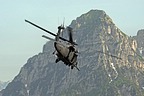 HH-60G Pave Hawk moves away from training zone, in the background the Alpine mountains