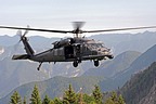 HH-60G Pave Hawk moves away from training zone, in the background the Alpine mountains