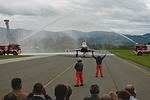 The Air Base Fire Deparment welcomes 7L-WA with a traditional gate of water.